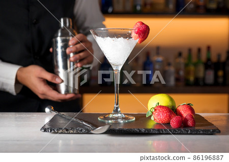Expert barman is making cocktail at night club. 86196887