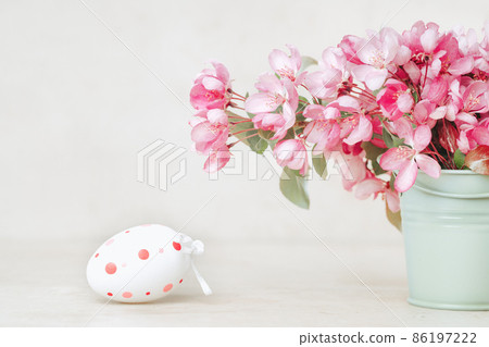 Spring blooming tree branches and easter egg in a vase on pastel background Spring blooming tree branches and easter egg in a vase on pastel background 86197222