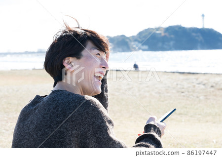 A man looking at a smartphone in Enoshima A man looking at a smartphone in Enoshima 86197447