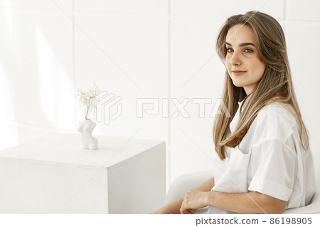 Portrait of a pretty cute young girl. Beautiful positive girl in a white cotton shirt. Copy space 86198905