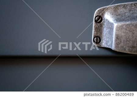 Stylish metal matte furniture handle on facade of gray kitchen cabinet, selective focus 86200489