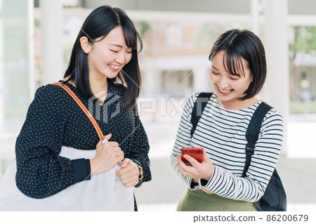 女大學生在校園裡看智能手機 86200679