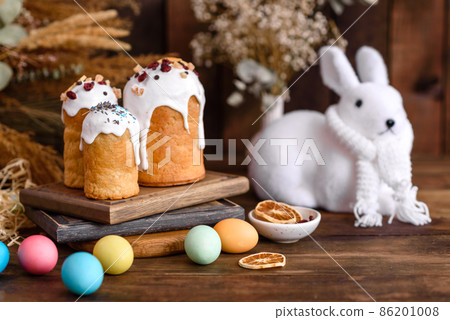 Easter eggs with cake on a brown wooden table Easter eggs with cake on a brown wooden table 86201008