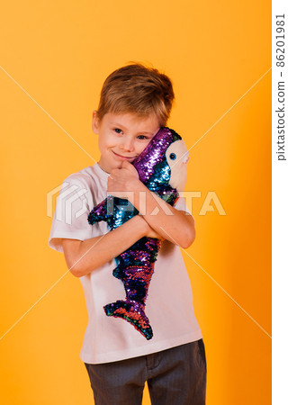 Child boy in yellow studio with toys fish shark toy Child boy in yellow studio with toys fish shark toy 86201981