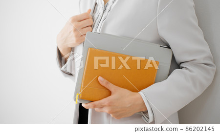 Career woman standing against a white wall 86202145