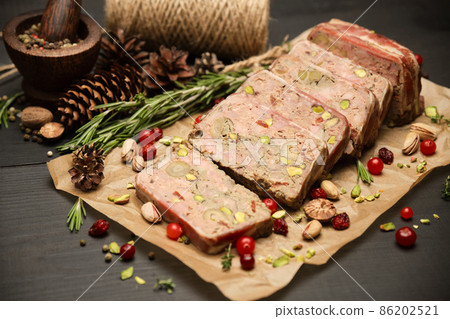 Sliced Traditional French terrine covered with bacon on dark wooden background 86202521