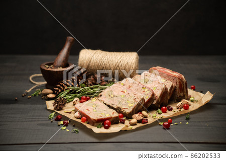 Sliced Traditional French terrine covered with bacon on dark wooden background 86202533