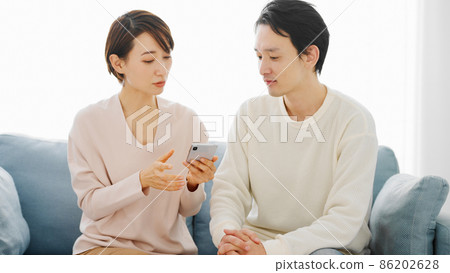 一對夫婦正在研究他們的智能手機 86202628
