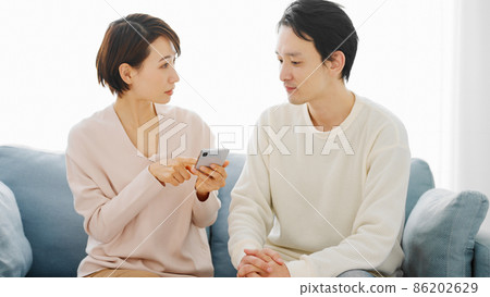 一對夫婦正在研究他們的智能手機 86202629