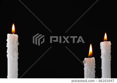 Burning candles over dark background. Halloween background with candles. Burning candles over dark background. Halloween background with candles. 86203847