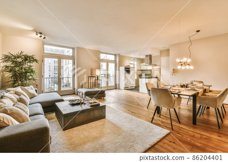 A luxurious living room with a huge gray sofa and decorative beige pillows A luxurious living room with a huge gray sofa and decorative beige pillows 86204401