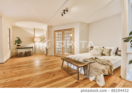A luxurious huge bedroom with a wooden floor and a pot of flowers 86204432