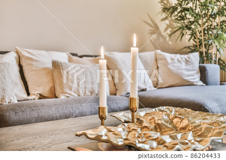A luxurious living room with a huge gray sofa and decorative beige pillows 86204433