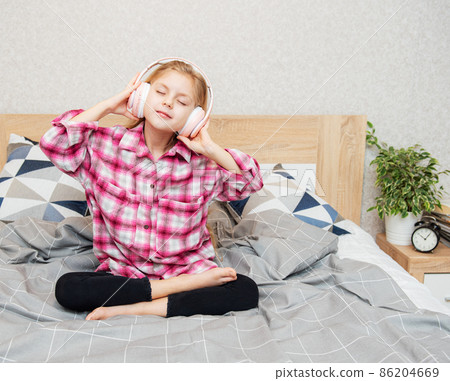 Cute girl listening music in the bedroom 86204669