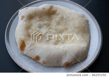 Something like bread that can be eaten in Central Asia and India where you can't tell the difference between naan and chapati 86205292
