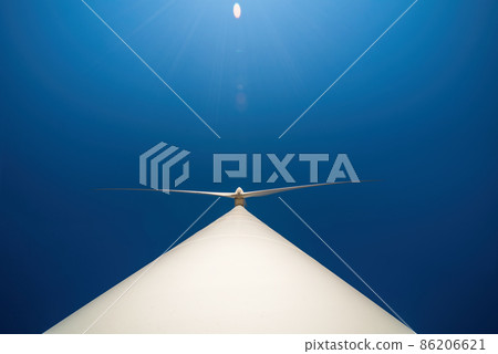 Large three-bladed horizontal-axis wind turbine against clear blue sky. Dramatic view from below Large three-bladed horizontal-axis wind turbine against clear blue sky. Dramatic view from below 86206621