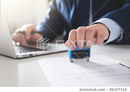Businessman working in office with stamp Businessman working in office with stamp 86207316
