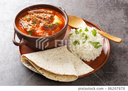 Hilachas are a favorite in Guatemala and are made of cooked and shredded beef that is simmered in a mildly spicy tomato sauce closeup in the plate. Horizontal Hilachas are a favorite in Guatemala and are made of cooked and shredded beef that is simmered in a mildly spicy tomato sauce closeup in the plate. Horizontal 86207878