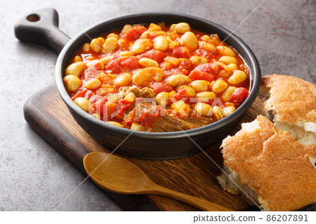 Moroccan loubia is a traditional dish consisting of stewed white beans closeup in the bowl on the table. Horizontal 86207891