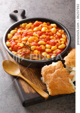 Moroccan White Beans Loubia with Tomatoes and Turmeric closeup in the bowl. Vertical 86207892