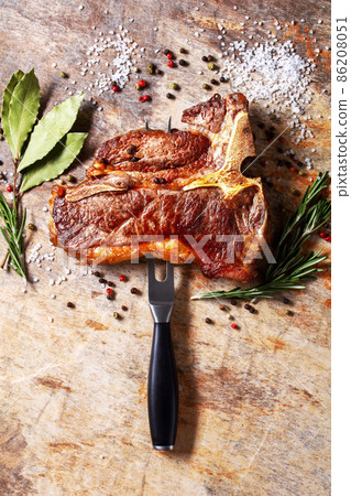 porterhouse steak is speared with carving fork 86208051