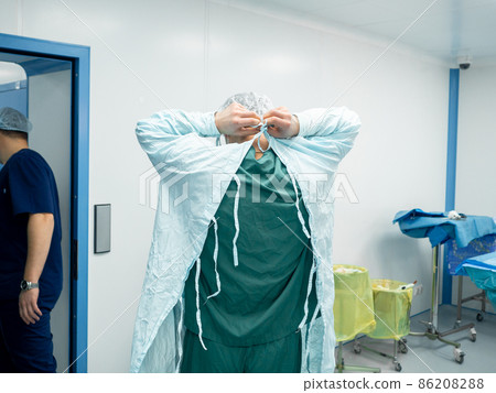 The surgeon undresses after surgery. 86208288