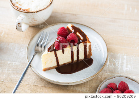 Cheesecake slice with chocolate sauce Cheesecake slice with chocolate sauce 86209209