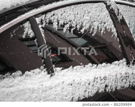 Sticky wet snow on car window and door with reflection Sticky wet snow on car window and door with reflection 86209984