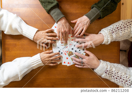 Hands of three senior women mixing playing cards on the table Hands of three senior women mixing playing cards on the table 86211208