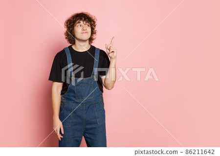 Studio shot of young cute man, student in black t-shirt isolated on pink background. Concept of emotions, facial expression, youth, aspiration, sales Studio shot of young cute man, student in black t-shirt isolated on pink background. Concept of emotions, facial expression, youth, aspiration, sales 86211642