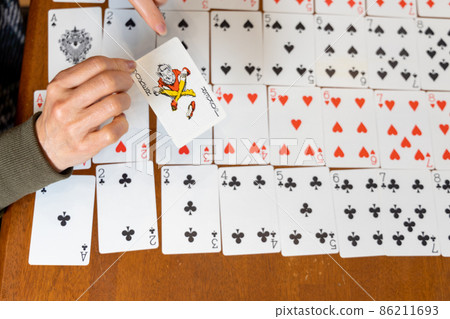 Senior woman with a playing card joker 86211693