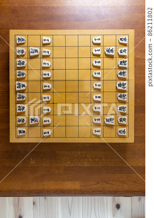 Shogi pieces lined up with the shogi board Shogi pieces lined up with the shogi board 86211802