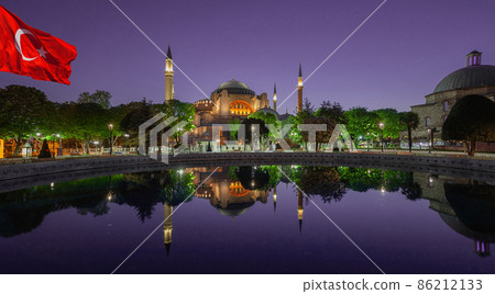 Hagia Sophia Mosque under purple sky and Turkish flag in Istanbul 86212133