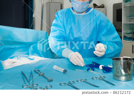 Hands of a surgeon in white gloves working with sterile surgical instruments Hands of a surgeon in white gloves working with sterile surgical instruments 86212172