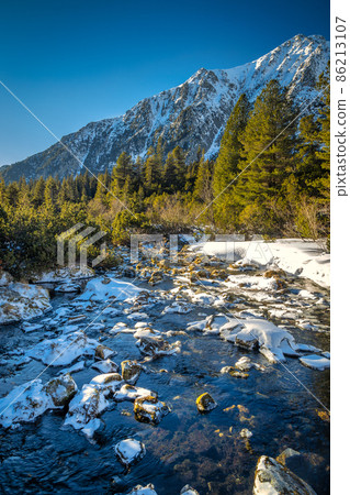 View of the landscape with stream in vallye of snowy mountains. View of the landscape with stream in vallye of snowy mountains. 86213107