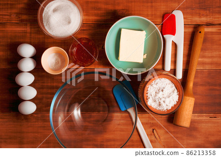 Bakery ingredients and kitchen utensils on wooden rural kitchen table for baking thematic background. Bakery ingredients and kitchen utensils on wooden rural kitchen table for baking thematic background. 86213358