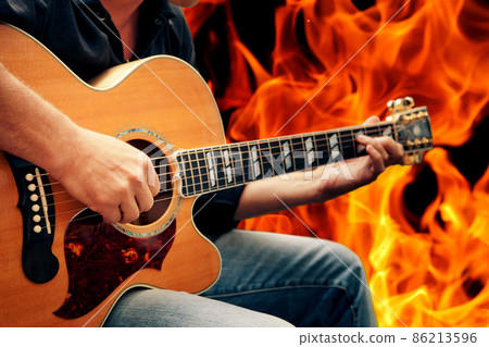 man playing guitar against fire background man playing guitar against fire background 86213596