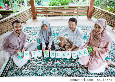 Muslim family making paper decorations in the gazebo Muslim family making paper decorations in the gazebo 86214365