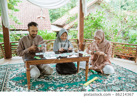 Father, mother and daughter prepare home decorations Father, mother and daughter prepare home decorations 86214367