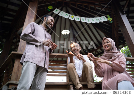 Father, Mother and son burning fireworks celebrating Eid Mubarak 86214368