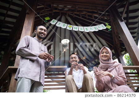 Asian father, mother and son smiling while lighting fireworks together Asian father, mother and son smiling while lighting fireworks together 86214370