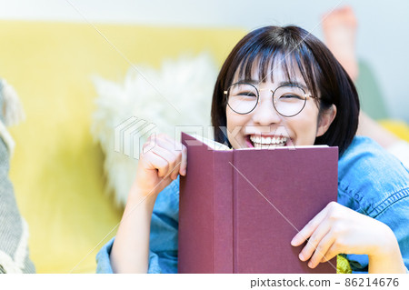 Woman lying on the couch and reading Woman lying on the couch and reading 86214676