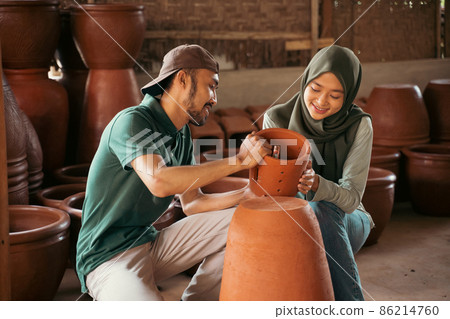 Young man and veiled girl looking at the pottery Young man and veiled girl looking at the pottery 86214760