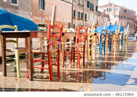 Colorful chairs in a row along Venetian canal Colorful chairs in a row along Venetian canal 86215969