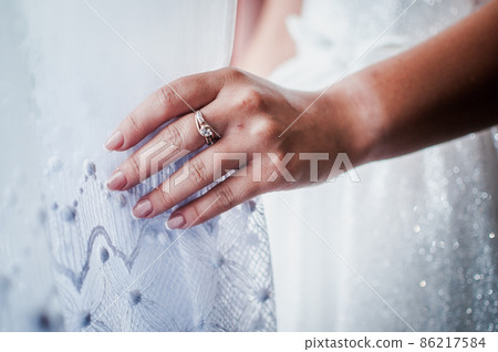 the bride holds a gold ring in her hands 86217584