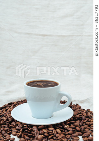 Cup of coffee and coffee beans on beige background Cup of coffee and coffee beans on beige background 86217793