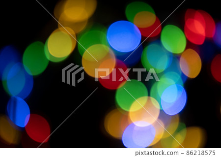 Defocused bokeh lights on black background, an abstract naturally blurred backdrop for Christmas eve or birthday party. Festive light texture. Colorful garland in blur. Overlay effect for design Defocused bokeh lights on black background, an abstract naturally blurred backdrop for Christmas eve or birthday party. Festive light texture. Colorful garland in blur. Overlay effect for design 86218575