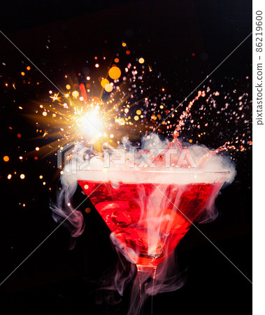 red cocktail with splash, sparkler and ice vapor 86219600