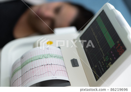 Pregnant Woman On Hospital Couch During Medical Control Cardiotocography. Gynecologist Doctor Hands Turn On Adjust CTG Device Clinic Consultant. Examine Expectant Belly Baby Mother Healthcare Check Up 86219696