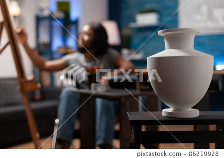 Selective focus on white vase standing on table for artist inspiration Selective focus on white vase standing on table for artist inspiration 86219928